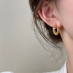 Unregelmäßige goldene C-Creolen mit minimalistisch strukturierter Oberfläche