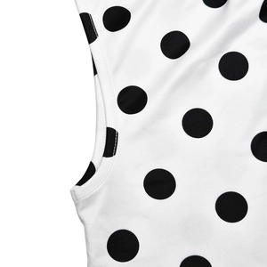 Gros plan sur tissu blanc à pois noirs montrant la texture douce et les coutures