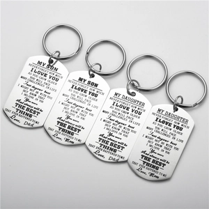 Detailed view of polished stainless steel dog tag keychains with laser-engraved quotes