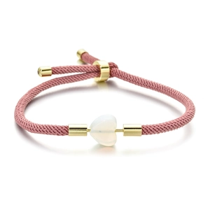 Handmade pink woven adjustable bracelet with heart-shaped white stone and gold accents