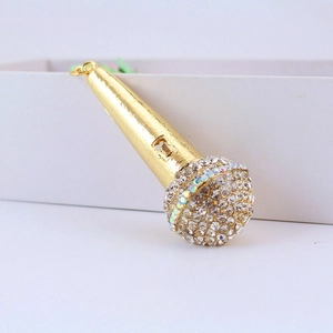 Sparkling gold microphone keychain with colorful rhinestones on a minimalist background