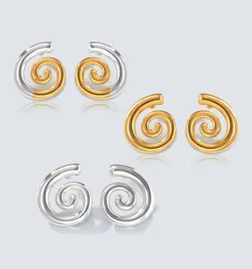 Détail de boucles d'oreilles spirales modernes en acier titane poli or et argent