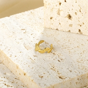 Macro shot of gold-plated geometric ring with unique texture on light stone