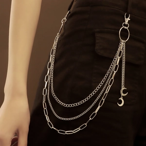 Detail showing multi-layer silver metal waist chain with crescent moon pendants on a model