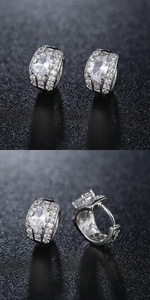 Macro shot of silver wide hoop earrings with large clear stone and pavé zircon crystals