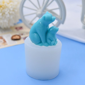 White silicone polar bear candle mold with blue finished bear figurine on blue background