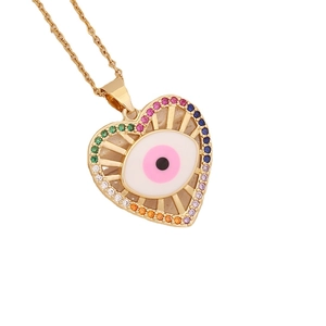 Golden heart necklace with evil eye pendant and colorful micro-set zircons on white backdrop