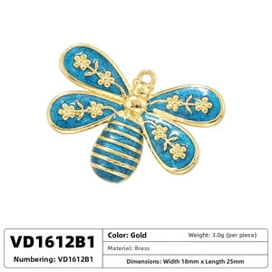 Macro detail of brass bee pendant with blue enamel wings and golden flower patterns