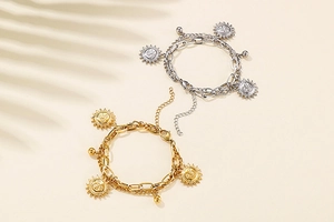 Detailed macro view of double-layer chain bracelets with sun face pendants and lobster clasp