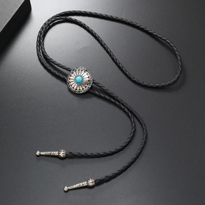 Detailed macro of vintage silver bolo tie with turquoise stone on woven leather cord