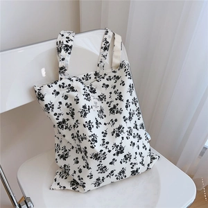 Detailed close-up of a floral cotton tote bag on a white chair with natural soft lighting