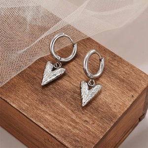 Silver heart pendant hoop earrings with hammered texture and minimalist industrial design