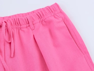 Détail du pantalon en lin rose montrant la taille élastique, le cordon et la texture