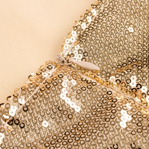 Detailaufnahme des goldenen Paillettenstoffs und unsichtbaren Reißverschlusses am Kleid