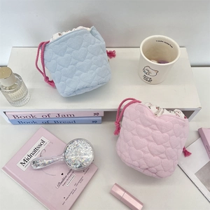 Detail of heart-quilted drawstring storage bags with floral lining and pink ropes