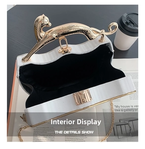 Detail shot of white box bag interior with gold leopard handle and metal chain
