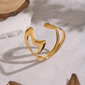 Bracelet jonc ouvert cœur évidé plaqué or 18 carats sur fond de marbre chic