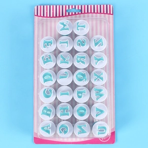Detailed set of 26 alphabet cookie cutters in striped blister packaging over blue background