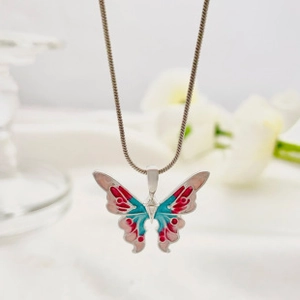 Detailed close-up of a silver butterfly pendant with vibrant red and blue enamel finish