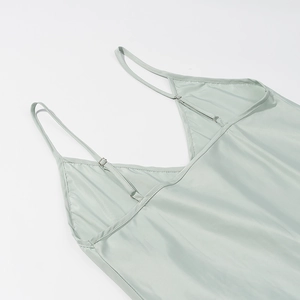 Detail view of mint green satin dress showing V-neckline and adjustable spaghetti straps