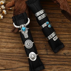 Detail of vintage turquoise ring set on leather with cattle engravings and cow skull motif