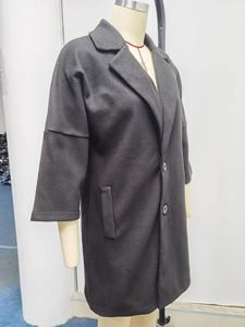 Gros plan du manteau noir en laine avec revers classiques et fermeture à double bouton