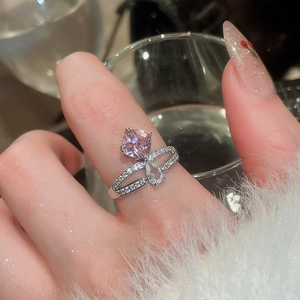 Close-up of sparkling silver ring with pink square and white pear-shaped zircon stones