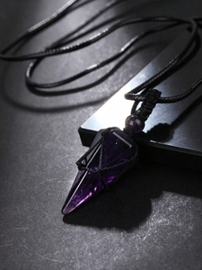 Macro detail of hexagonal amethyst pendulum pendant with black woven mesh setting