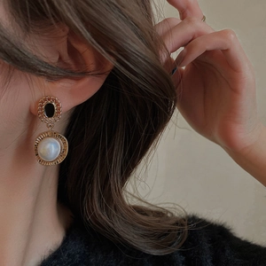 Boucles d'oreilles vintage en métal avec pierres noires et perles sur un mannequin