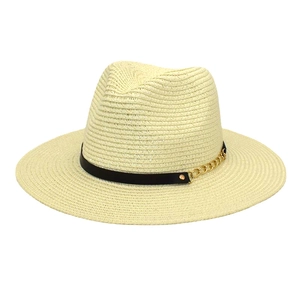 Detail of beige straw fedora featuring a black leather band and gold chain accent