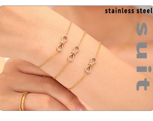 Gros plan détaillé d'un ensemble de trois bracelets infini dorés avec pierres en zircon