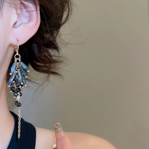 Detailed shot of bohemian tassel earrings featuring deep blue beads and gold chains