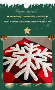 Macro detail of red and black buffalo plaid fabric with white embroidered snowflake