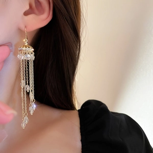 Elegant gold chain fringe earrings with crystals worn by model in a profile view