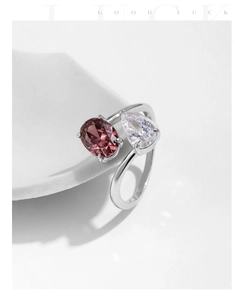 Detail of s925 silver open ring featuring pink oval and clear pear-cut gemstones
