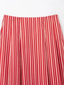 Gros plan sur la texture du tissu rayé rouge et blanc et la taille élastique de la jupe