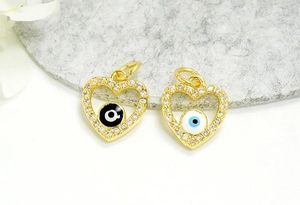 Detail of 18K gold plated heart evil eye charms with pavé crystals and colorful enamel