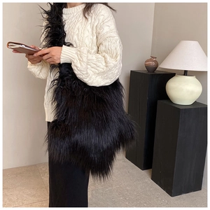Close-up of black fuzzy plush crossbody bag with fluffy texture on a fashion model