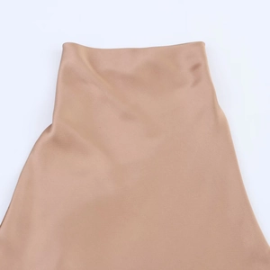 Detailed macro view of the champagne satin fabric texture and seamless waistline design