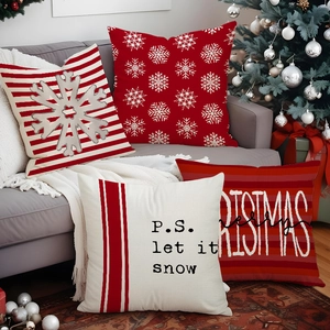 Set of four red and white Christmas pillow covers on a sofa with holiday decor