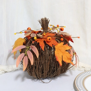 Close-up of autumn pumpkin decor with woven vines, maple leaves and berries