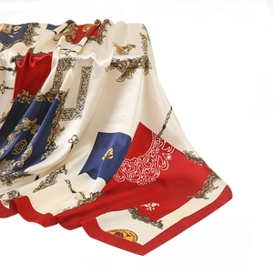 Detail view of luxurious silk-like square scarf with gold chain and baroque crest patterns
