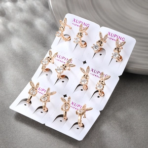 Detailed view of six pairs of gold rabbit earrings with round zircons on display card