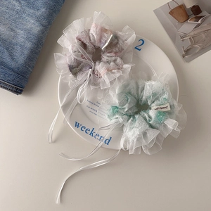 Detailed texture of lace organza scrunchies with sweet bows in lavender and mint