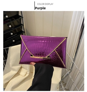 Detail of purple croc-effect envelope clutch with gold metal trim and magnetic fastener