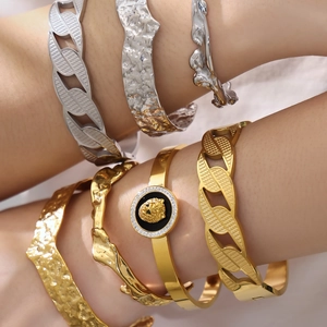 Gold and silver stackable bracelets with lion head emblem and hammered metal texture