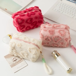 Detailed view of plush makeup bags with 3D heart textures and decorative zipper pulls
