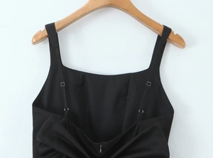 Detail view showing the adjustable spaghetti straps and hidden back zipper of a black dress