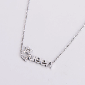 Macro detail of silver Queen pendant with crown design and sparkling pavé crystals