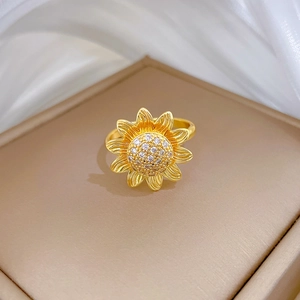 Close-up of golden sunflower ring with white cubic zirconia in luxury jewelry box